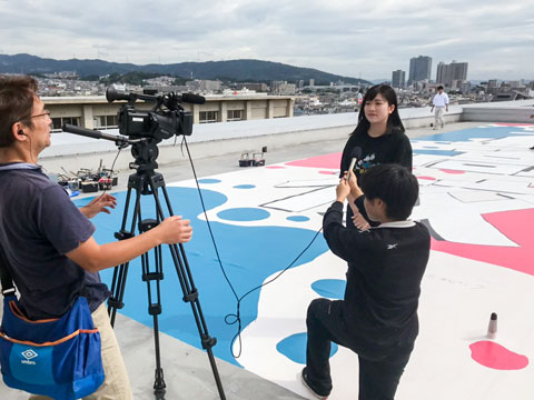 今回の塗装を発案された生徒さんがケーブル局の方にインタビューを受ける（2019年9月28日　三島高校）